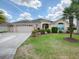 Elegant single-story home with a three-car garage, well-manicured lawn, and beautiful landscaping at 1751 Ashwood Run, The Villages, FL 32162
