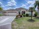 Charming home with a manicured lawn, a three-car garage, and beautiful landscaping at 1751 Ashwood Run, The Villages, FL 32162