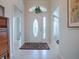 Inviting foyer with tile flooring, arched doorway, decorative door, and transom window for lots of natural light at 1751 Ashwood Run, The Villages, FL 32162