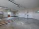 The garage features concrete floors, bright lighting, storage, and utility sink at 1751 Ashwood Run, The Villages, FL 32162