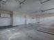 Well lit three car garage with concrete floors, storage, and utility sink at 1751 Ashwood Run, The Villages, FL 32162