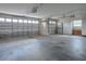 Spacious three car garage featuring high ceilings, concrete floors, and ample storage cabinetry at 1751 Ashwood Run, The Villages, FL 32162
