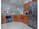 Open-concept kitchen with granite countertops, stainless steel refrigerator, ample cabinets, and tile flooring at 1751 Ashwood Run, The Villages, FL 32162