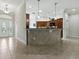 Inviting kitchen with stone countertops, tile flooring, and decorative tile on the kitchen island with bar seating at 1751 Ashwood Run, The Villages, FL 32162