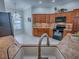 Open kitchen and dining area featuring stone countertops, black appliances, and beautiful wooden cabinets at 1751 Ashwood Run, The Villages, FL 32162