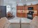Charming kitchen featuring black appliances, granite countertops, and ample wood cabinets at 1751 Ashwood Run, The Villages, FL 32162