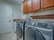 Well-equipped laundry room with cabinets, sink, and modern washer and dryer units at 1751 Ashwood Run, The Villages, FL 32162