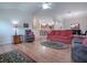 The inviting living room features an open layout, wood floors, and comfortable seating arrangements at 1751 Ashwood Run, The Villages, FL 32162
