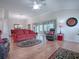 Cozy living room boasts hardwood floors, comfortable seating, and ample natural light from sliding glass doors at 1751 Ashwood Run, The Villages, FL 32162