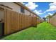 Long, grassy backyard area with wooden fence at 6299 River Run Pl # 198, Orlando, FL 32807