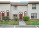 Inviting exterior of townhome with red door and well-manicured landscaping at 6299 River Run Pl # 198, Orlando, FL 32807