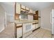 Kitchen features wood cabinets, white appliances, and tile floor at 6299 River Run Pl # 198, Orlando, FL 32807