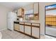 Galley kitchen with white appliances and wood cabinets at 6299 River Run Pl # 198, Orlando, FL 32807