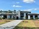 Modern home with gray tile roof and paver driveway at 16122 Pendio Dr, Bella Collina, FL 34756