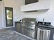 Modern outdoor kitchen with stainless steel appliances at 16122 Pendio Dr, Bella Collina, FL 34756