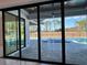 Sliding glass doors reveal a private pool and patio area at 16122 Pendio Dr, Bella Collina, FL 34756