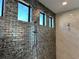 Walk-in shower with textured tile and multiple windows at 16122 Pendio Dr, Bella Collina, FL 34756