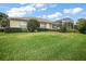 A view of the home's backyard, defined by its vibrant lawn and privacy landscaping at 8043 Pine Hollow Dr, Mount Dora, FL 32757