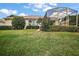 View of a well-kept backyard with lawn and privacy hedges at 8043 Pine Hollow Dr, Mount Dora, FL 32757