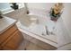 A well-maintained bathtub with a tiled backsplash, chrome faucet, and decorative accents at 8043 Pine Hollow Dr, Mount Dora, FL 32757