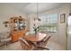 Cozy breakfast nook with wooden table, four chairs, large window, and a curio cabinet at 8043 Pine Hollow Dr, Mount Dora, FL 32757