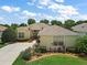 Well-manicured front lawn and flower beds leading to the front entrance of this cream-colored home at 8043 Pine Hollow Dr, Mount Dora, FL 32757