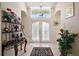 Inviting foyer featuring a decorative rug, marble-topped console table, and ample natural light at 8043 Pine Hollow Dr, Mount Dora, FL 32757