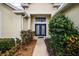 Close-up of the home's entry featuring a decorative blue double door and lush landscaping at 8043 Pine Hollow Dr, Mount Dora, FL 32757