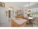 Kitchen island with additional storage near the breakfast nook featuring a wood table, chairs, and natural light at 8043 Pine Hollow Dr, Mount Dora, FL 32757