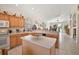 Bright kitchen with an island, light wood cabinets, and tile flooring extending into the adjacent living spaces at 8043 Pine Hollow Dr, Mount Dora, FL 32757