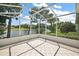 View of the home's tiled lanai overlooking a green yard and lake at 8043 Pine Hollow Dr, Mount Dora, FL 32757