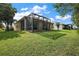 House with a screened porch and lush green backyard at 16984 Se 109Th Ave, Summerfield, FL 34491