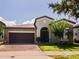 Charming single-story home with a two-car garage, a well-manicured lawn, and a brick-paved driveway at 9342 Oglethorpe Dr, Groveland, FL 34736
