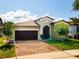 Charming single-story home with a two-car garage, a well-manicured lawn, and a brick-paved driveway at 9342 Oglethorpe Dr, Groveland, FL 34736