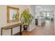 Bright hallway featuring an ornate mirror, indoor plants, and tile flooring leading to an open-concept living space at 9342 Oglethorpe Dr, Groveland, FL 34736