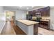Spacious kitchen featuring an island with sink, dark wood cabinetry, and modern appliances at 9342 Oglethorpe Dr, Groveland, FL 34736