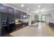 Open-concept kitchen with dark wood cabinets, stainless steel appliances, and a spacious island with a double sink at 9342 Oglethorpe Dr, Groveland, FL 34736