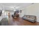 Open-concept living space featuring hardwood floors, a dining table, and a comfortable sofa at 9342 Oglethorpe Dr, Groveland, FL 34736