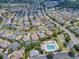 Aerial view of a house and community, showing neighborhood, pool, and property lines at 486 Troy Loop, The Villages, FL 32162