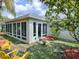 Backyard view of house with sunroom addition and landscaping at 486 Troy Loop, The Villages, FL 32162