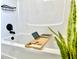 Relaxing white bathtub with a convenient wooden bath tray and modern black fixtures at 14598 Sw 34Th Terrace Rd, Ocala, FL 34473