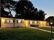 Exterior view of the home at dusk showcasing the manicured lawn and mature trees at 14598 Sw 34Th Terrace Rd, Ocala, FL 34473