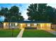 Charming single-story home with a well-manicured lawn and welcoming front entrance, lit up at dusk at 14598 Sw 34Th Terrace Rd, Ocala, FL 34473