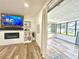Comfortable living room featuring modern electric fireplace and adjacent sunroom at 14598 Sw 34Th Terrace Rd, Ocala, FL 34473