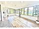 Bright sunroom featuring large windows, wood-look flooring, and natural light, perfect for relaxation at 14598 Sw 34Th Terrace Rd, Ocala, FL 34473