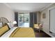 Bright bedroom with neutral tones features a sunlit balcony and comfortable furnishings at 601 W Old Hwy 441 # 11B, Mount Dora, FL 32757