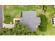 Aerial view of a well-maintained property featuring a gray roof, lush landscaping, and a long driveway at 9215 Se 177Th Simons Ln, The Villages, FL 32162