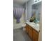 Bathroom featuring vanity with faux floral decor, toilet, and shower with curtain at 9215 Se 177Th Simons Ln, The Villages, FL 32162