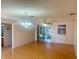 Bright living room with hardwood flooring, ceiling fan, chandelier and sliding glass doors to the lanai at 9215 Se 177Th Simons Ln, The Villages, FL 32162