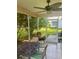 Cozy screened patio with outdoor seating, a ceiling fan, and a peaceful view of the backyard and lush foliage at 9215 Se 177Th Simons Ln, The Villages, FL 32162